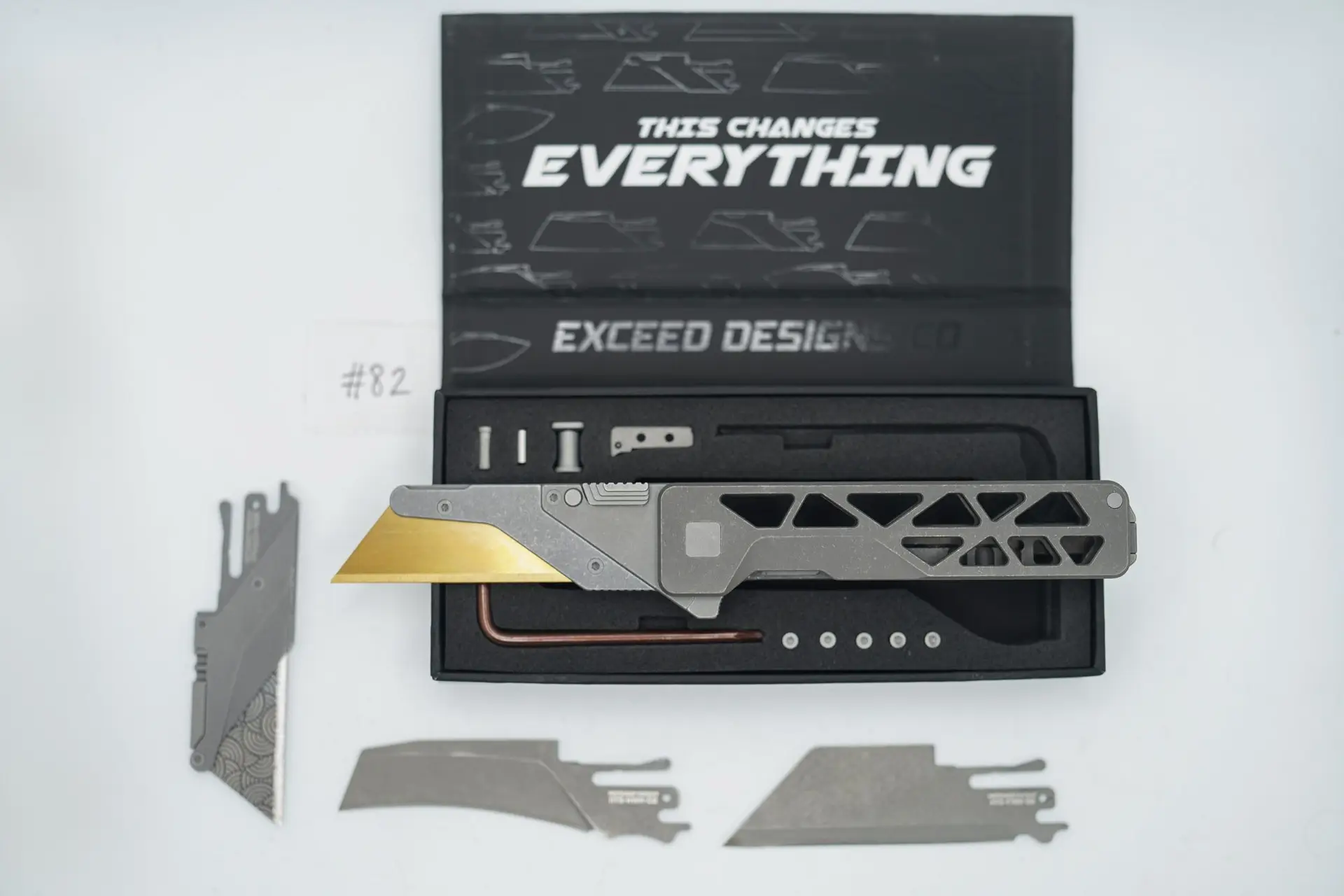 BUILD #82 — Condition 10/10 — TiRant ULTRA Skeleton ‘SKULTRA’ Dark Wash Titanium W/Blasted Grey Hardware + Original Box W/Spare Grey Blasted Hardware Kit / Lock Bar insert + V2 Razor Blade Quick Release Hotswap Insert + D2 Blem Stonewashed Hawkbill Hotswap Blade + D2 Stonewashed Full Razor Hotswap Insert + 3X Custom Laser Engraved Razor Blades