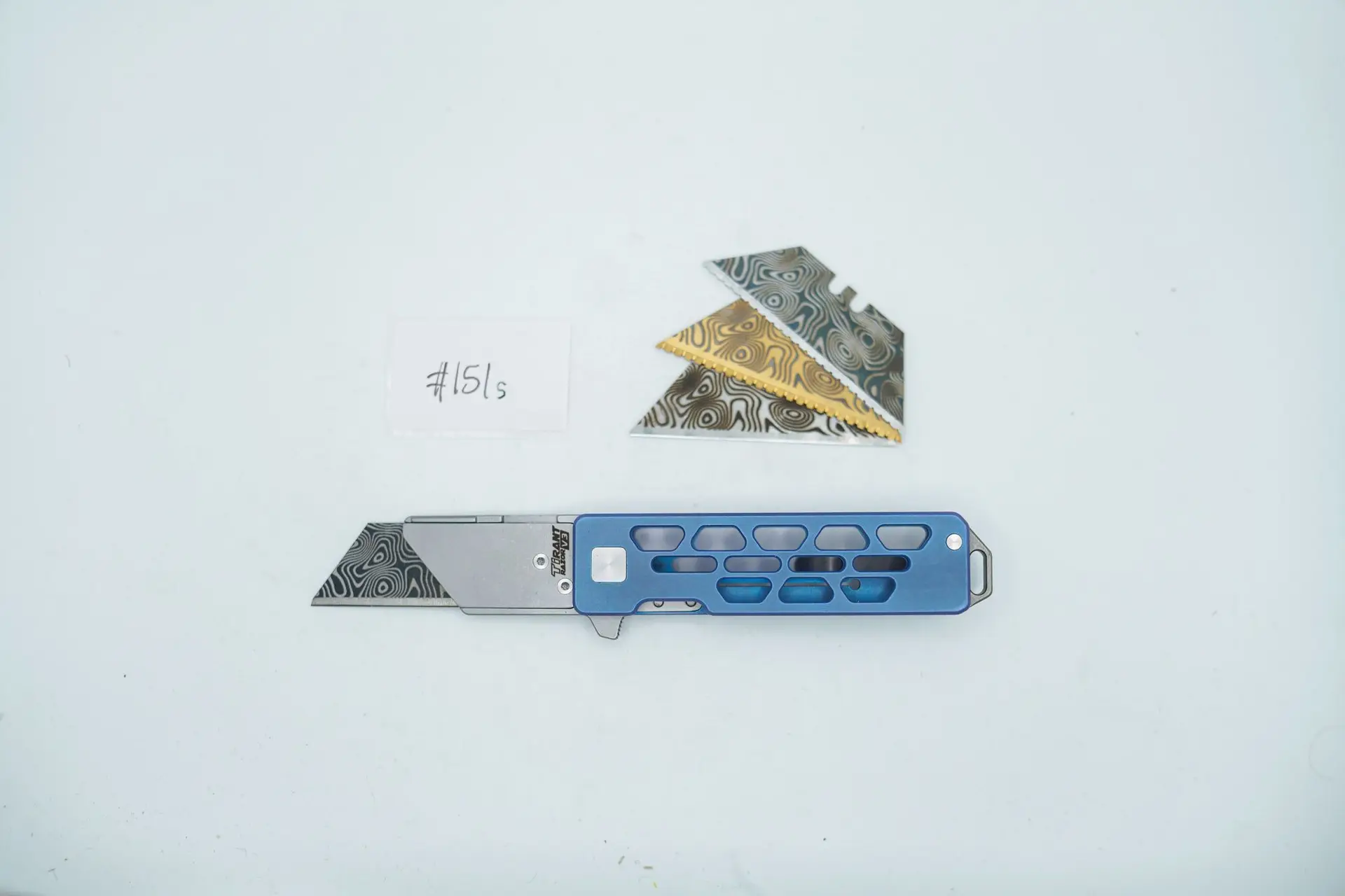 BUILD #151s — Condition 9/10 — TiRant RAZOR V3 Skeleton + Custom Hand-Applied Aqua-Blue ANO + Pre-installed SKIFF Bearings + 38MM Mini Clip + 3X Custom Laser Engraved Razor Blades From The ToolRoom